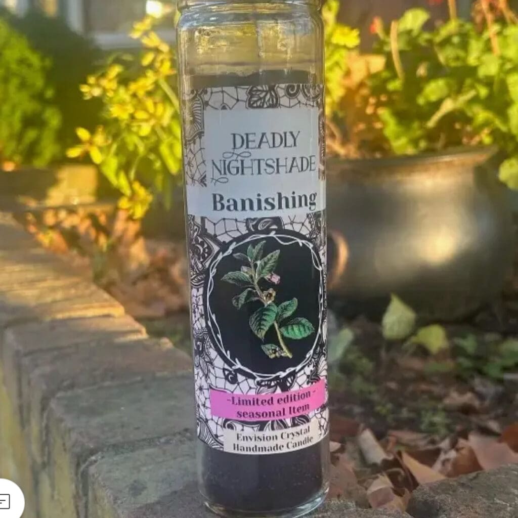 A small black candle labeled 'Death Brings Transformation' with decorative floral designs.