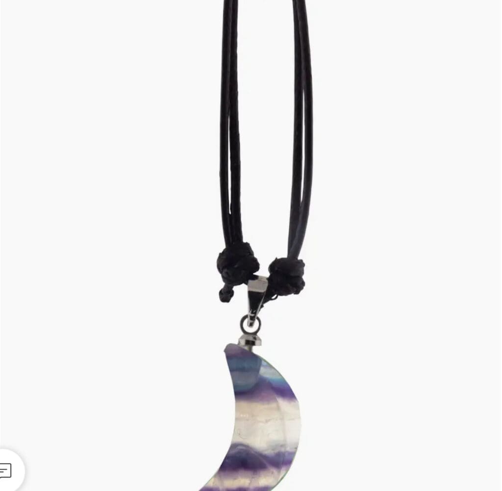A crescent moon pendant on a black cord necklace.